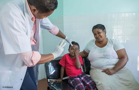 Visus-Test bei einem jungen Patienten, begleitet von seiner Mutter in Madagaskar