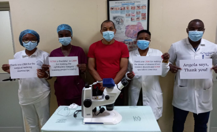 Ärzte mit Mikroskop und Schildern mit der Aufschrift „Danke CBM Luxemburg